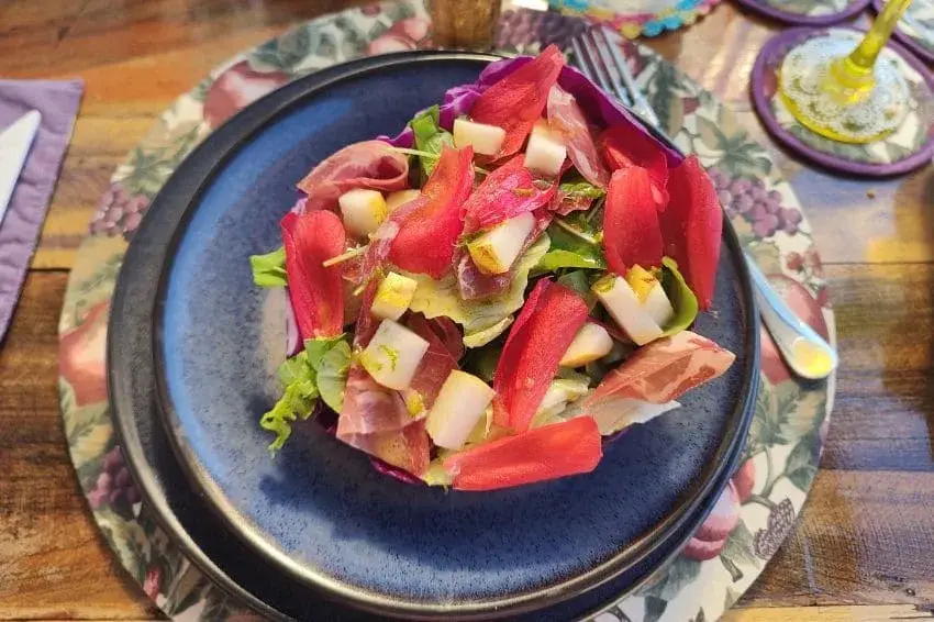 salada de folhas com hibisco e pera, bem colorida.