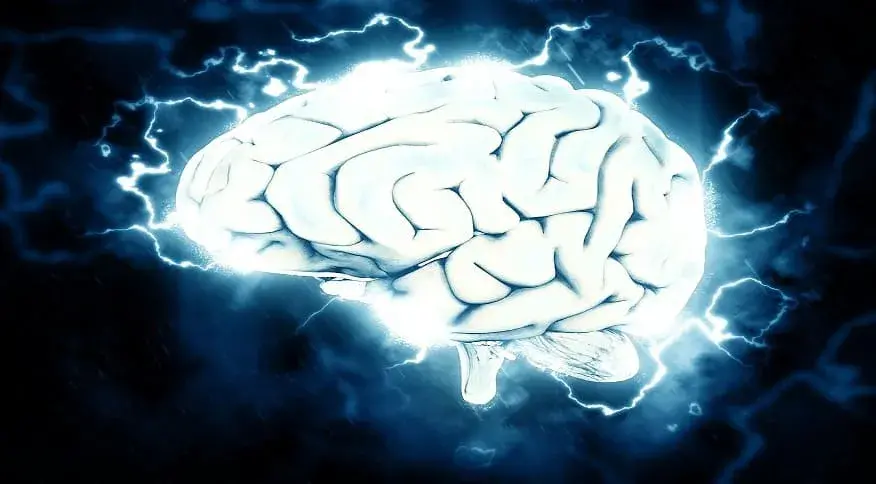 cerebro branco com raios de energia entorno, fundo escuro.